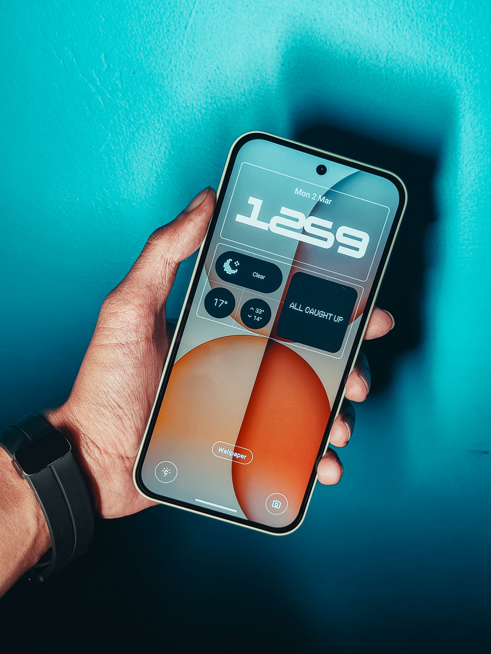 A hand holding an Android smartphone with a modern home screen